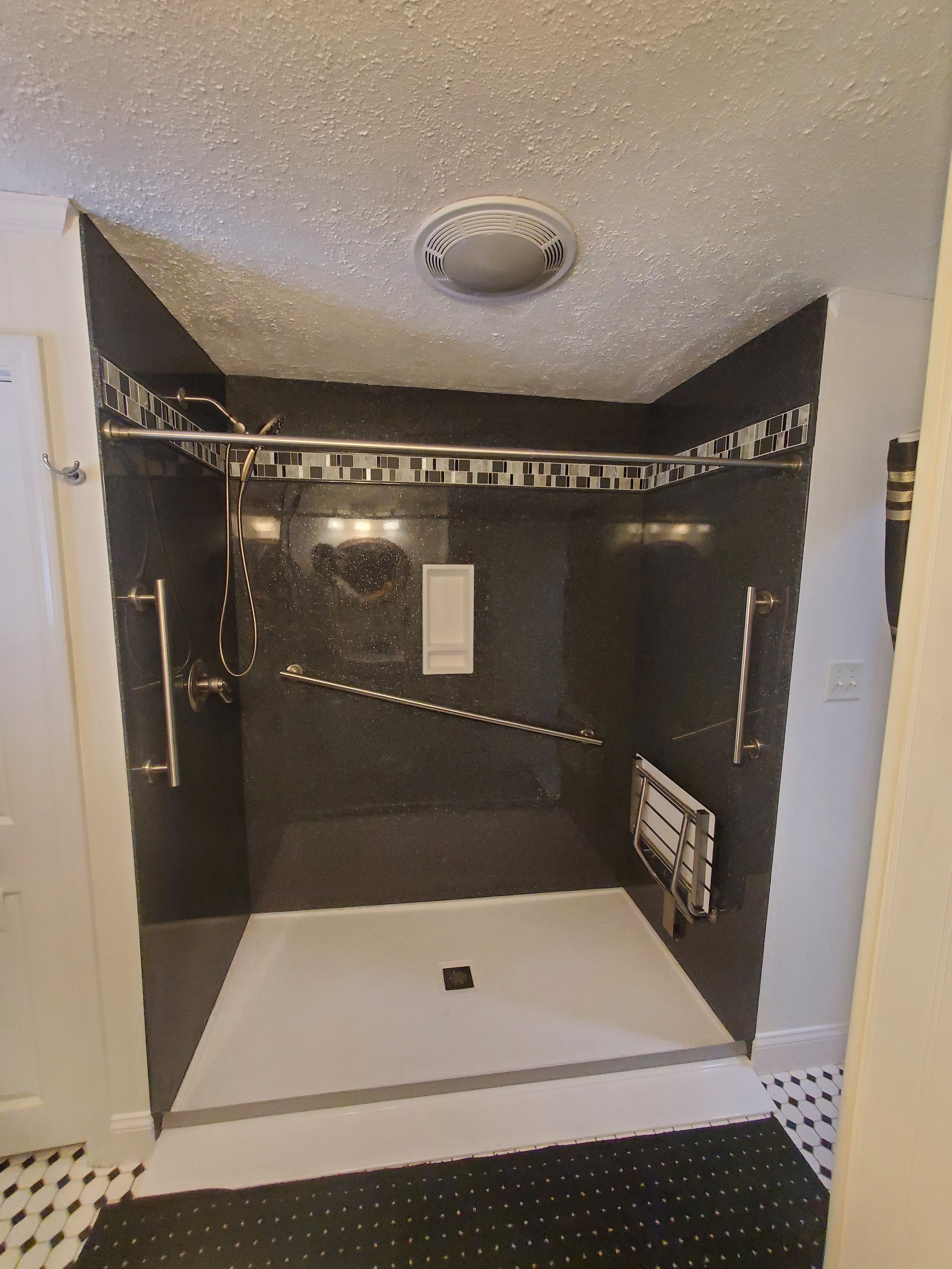 Custom solid stone panel ada accessible shower with grab bars and bench