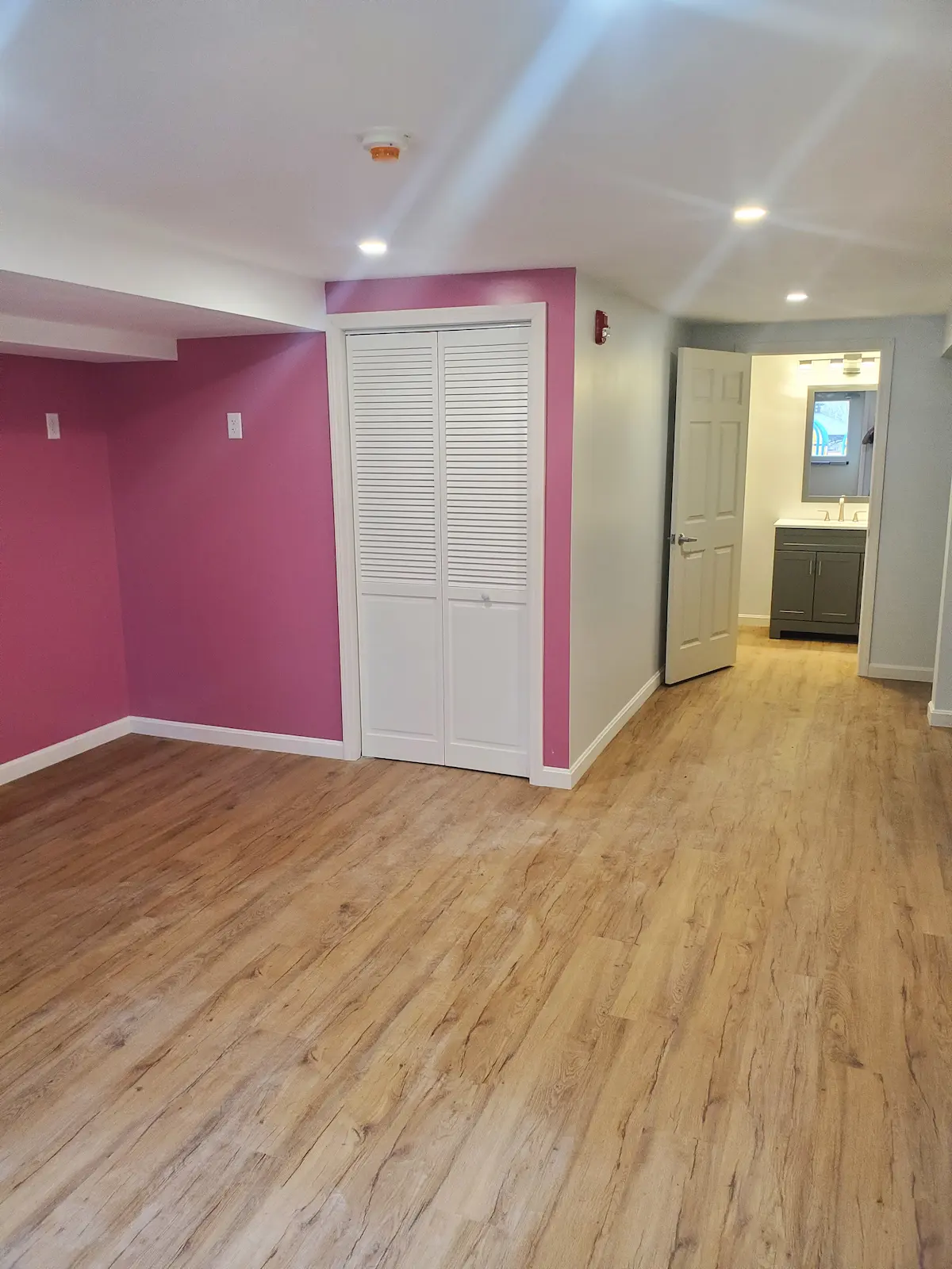 Finished basement living space with quality flooring and professional lighting installation