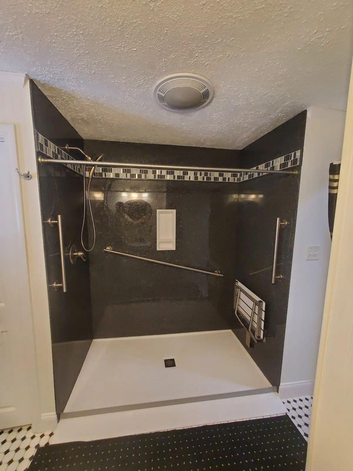 Custom solid stone panel ada accessible shower with grab bars and bench